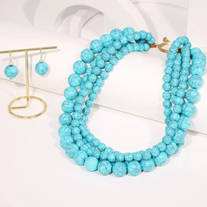 Détail d'un collier bohème multicouche en perles de turquoise et cœurs dorés