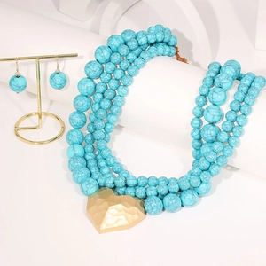 Détail d'un collier à quatre rangs de perles turquoises avec pendentif coeur martelé