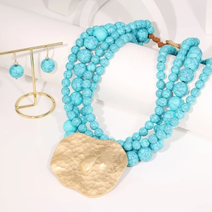 Détail du collier de perles turquoise à plusieurs rangs avec grand pendentif cœur doré
