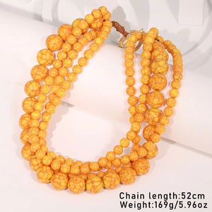 Detail of yellow multi-layer beaded necklace with heart pendant and marble texture