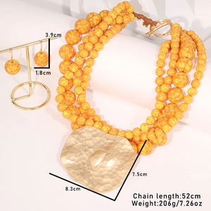 Detail of yellow beaded multi-layer necklace with hammered gold heart pendant