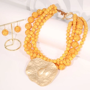 Five-layer yellow beaded necklace with a large gold hammered irregular metal pendant