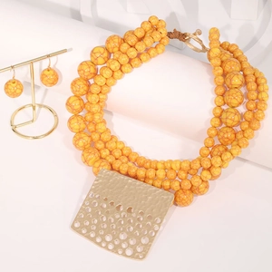 Detailed macro of bohemian beaded necklace set with hammer textured gold pendant