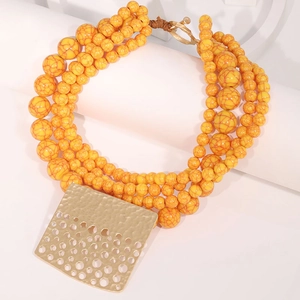 Detailed view of bohemian layered yellow marble beads with hammered gold square pendant