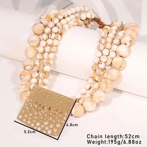 Detailed view of chunky multi-layer beaded necklace with square gold pendant and marble beads