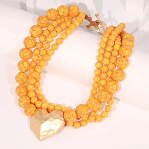 Detail of yellow marble acrylic beads and hammered gold heart pendant with OT clasp