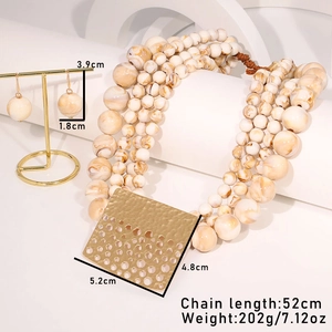 Detailed view of beaded layered necklace set with gold pendants and marble texture beads