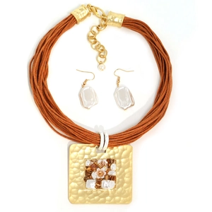 Détail du pendentif carré martelé doré avec pierre naturelle et perle sur cordon ciré