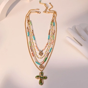 Collier multicouche bohème avec perles colorées et pendentif croix sur fond blanc