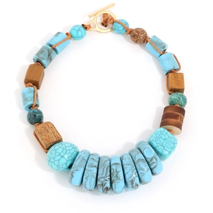 Handmade ethnic necklace with geometric turquoise beads and wood accents on white backdrop
