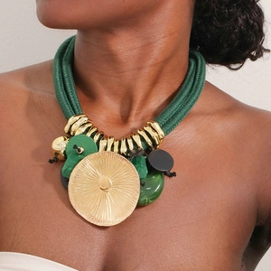 Statement necklace with bold green braided ropes and oversized gold lotus leaf pendant