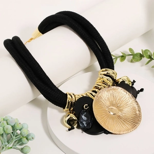 Detail of bohemian gold leaf pendant on black rope necklace with marble accents