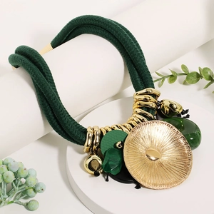 Detail of bohemian statement necklace with green woven ropes and golden lotus pendant
