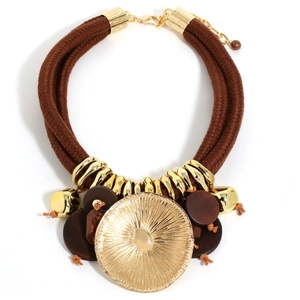 Detailed view of bohemian lotus leaf gold pendant with brown woven cord and wood