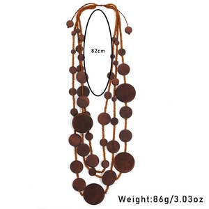 Detail of layered handmade wooden bead necklace with circular pendant accents