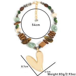 Détail d'un collier bohème avec perles en bois et grand pendentif coeur doré mat