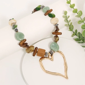 Collier bohème avec perles en pierre et bois et un pendentif cœur doré évidé
