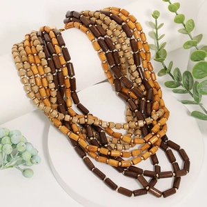 Collier multicouche bohème en perles de bois avec entretoises dorées sur socle blanc
