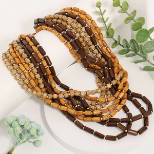 Collier multicouche bohème avec perles en bois marron et entretoises dorées sur un support blanc