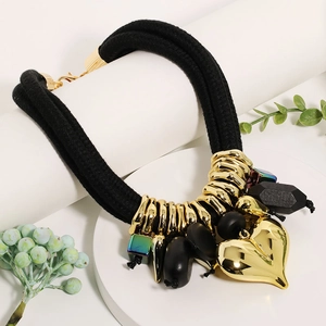 Detailed close-up of multilayer rope necklace with large gold heart pendant and beads