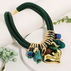 Close-up of bohemian layered cord necklace with large gold heart pendant and beads