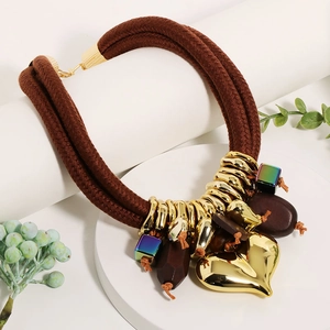 Detail of multi-strand chunky rope necklace with a large polished gold heart pendant