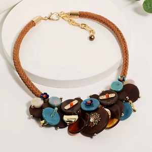 Handmade Bohemian necklace with colorful acrylic disks and braided cord on a white display
