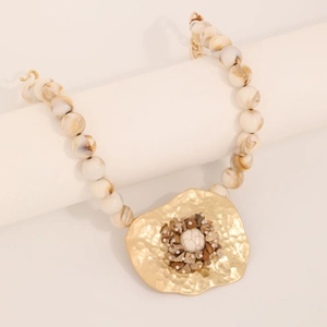 Handmade beaded necklace with large marble-style beads and textured gold metal pendant