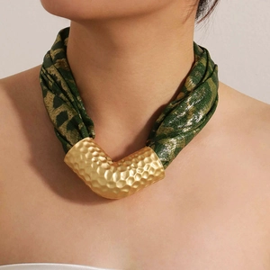 Close-up of leopard print fabric necklace with hammered gold V-shape metal pendant detail
