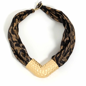 Detail of leopard print fabric necklace featuring a gold hammered V-shaped pendant