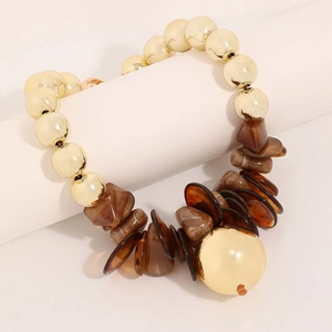 Bohemian gold bead necklace with brown resin geometric charms on a minimalist stand
