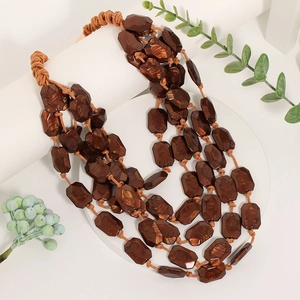Détail de perles d'ambre en acrylique multicouche sur un collier en corde tressée
