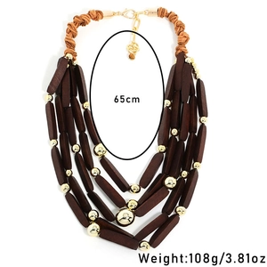 Dettaglio della collana bohémien a strati con perle di legno e dettagli in metallo