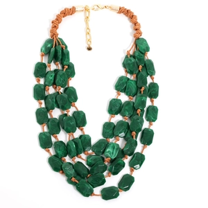 Détail des perles en acrylique marbré vert et cordon tressé de ce collier multicouche