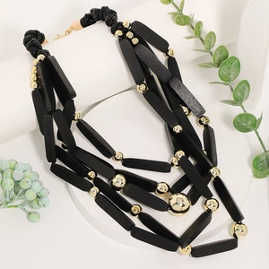 Collana boho multistrato con perle di legno nere allungate e sfere dorate lucide