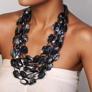 Collier multi-rangs en acrylique à perles marbrées porté par un mannequin femme
