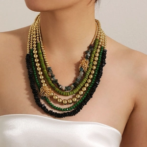 Detail view of multi-layer Bohemian beaded necklace with gold tassels on a model