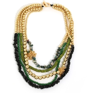 Close-up of bohemian layered beaded necklace with green glass and gold metal beads