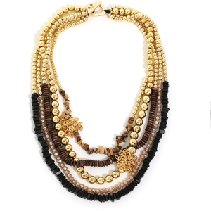 Macro view showing layered beads with gold hollow mesh spheres and stones in boho style