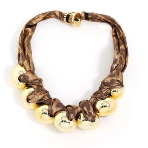 Detailed close-up of leopard print fabric necklace with large polished gold beads