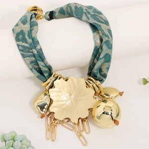 Detail of bohemian gold leaf pendant necklace with leopard print fabric cord and metal beads