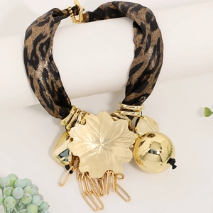 Close-up of leopard print fabric necklace with gold leaf pendant and chain tassels