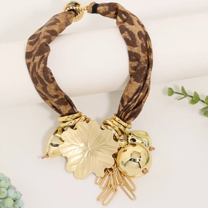 Detail of leopard print fabric necklace with gold leaf pendant and metal tassels