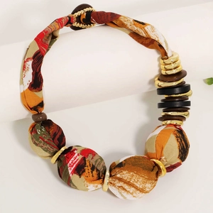 Collier bohème en tissu imprimé avec perles et anneaux dorés sur support