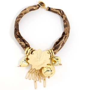 Detail of bohemian leopard print fabric necklace with gold leaf and tassel pendant