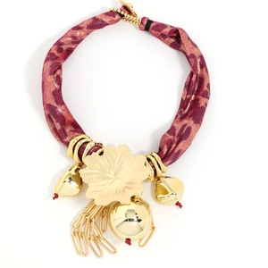 Detail view of golden maple leaf pendant with leopard print silk cord and round metal ball