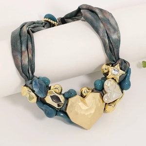 Detailed view of vintage leopard ribbon necklace featuring a hammered gold heart pendant