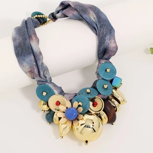 Detail of luxury ribbon necklace with metallic button flower pendant and beads