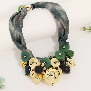 Detail of luxury ribbon necklace with marble-textured fabric and golden flower pendant