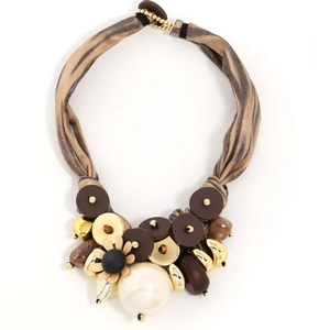 Detail of luxury ribbon necklace featuring oversized beads and tiger-print fabric wrap